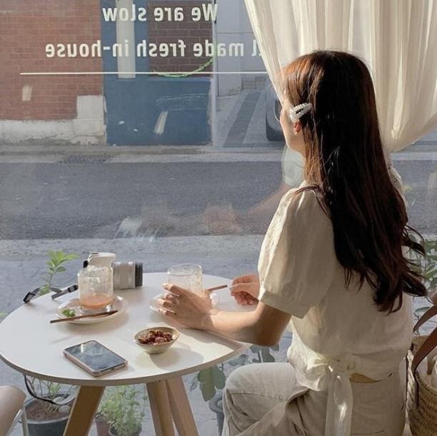 Bella sat at a cafe with her long straight hair accented with a hair clip